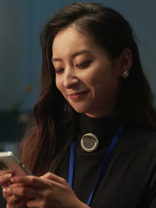A woman wearing EgoClip while using her phone